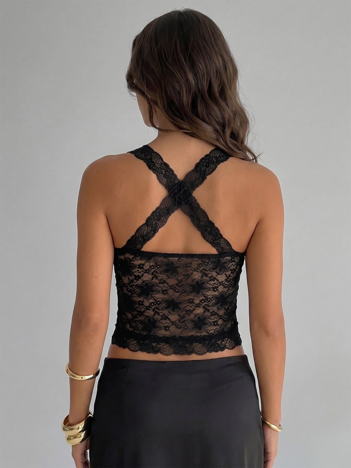 Back view of a black floral lace halter corset crop top with cross-back straps.