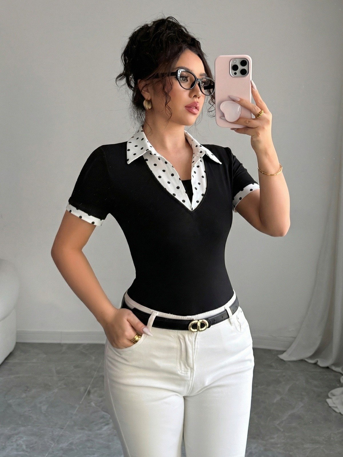 Mirror side view of a black fitted polo top with a white polka-dot collar and cuffs.