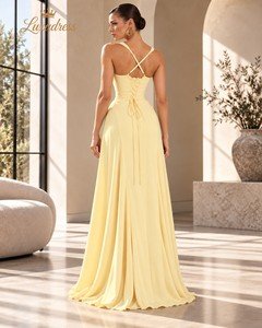 Back view of a butter yellow prom dress showing crossover straps, a lace-up corset back and a flowing floor-length skirt.