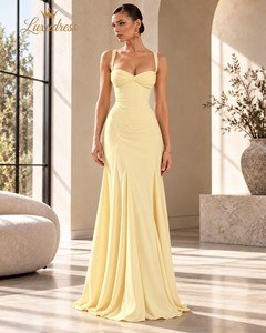 Front view of a butter yellow sweetheart prom dress with a twisted bust, shoulder straps and a flowing floor-length skirt.