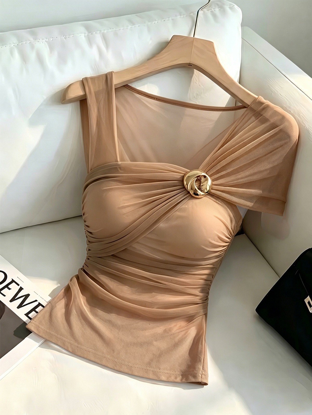 Hanger product display of a camel mesh one-shoulder ruched top with polished ring detail.