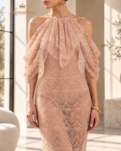 Close-up of a blush pink lace gown showing the gathered halter neckline, cascading draped sleeves and scalloped lace pattern.