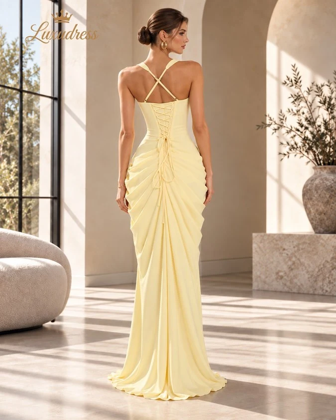 Back view of a butter yellow corset prom dress with crossed shoulder straps, lace-up fastening and gathered draping.