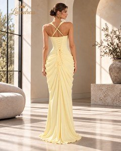 Back view of a butter yellow corset prom dress with crossed shoulder straps, lace-up fastening and gathered draping.