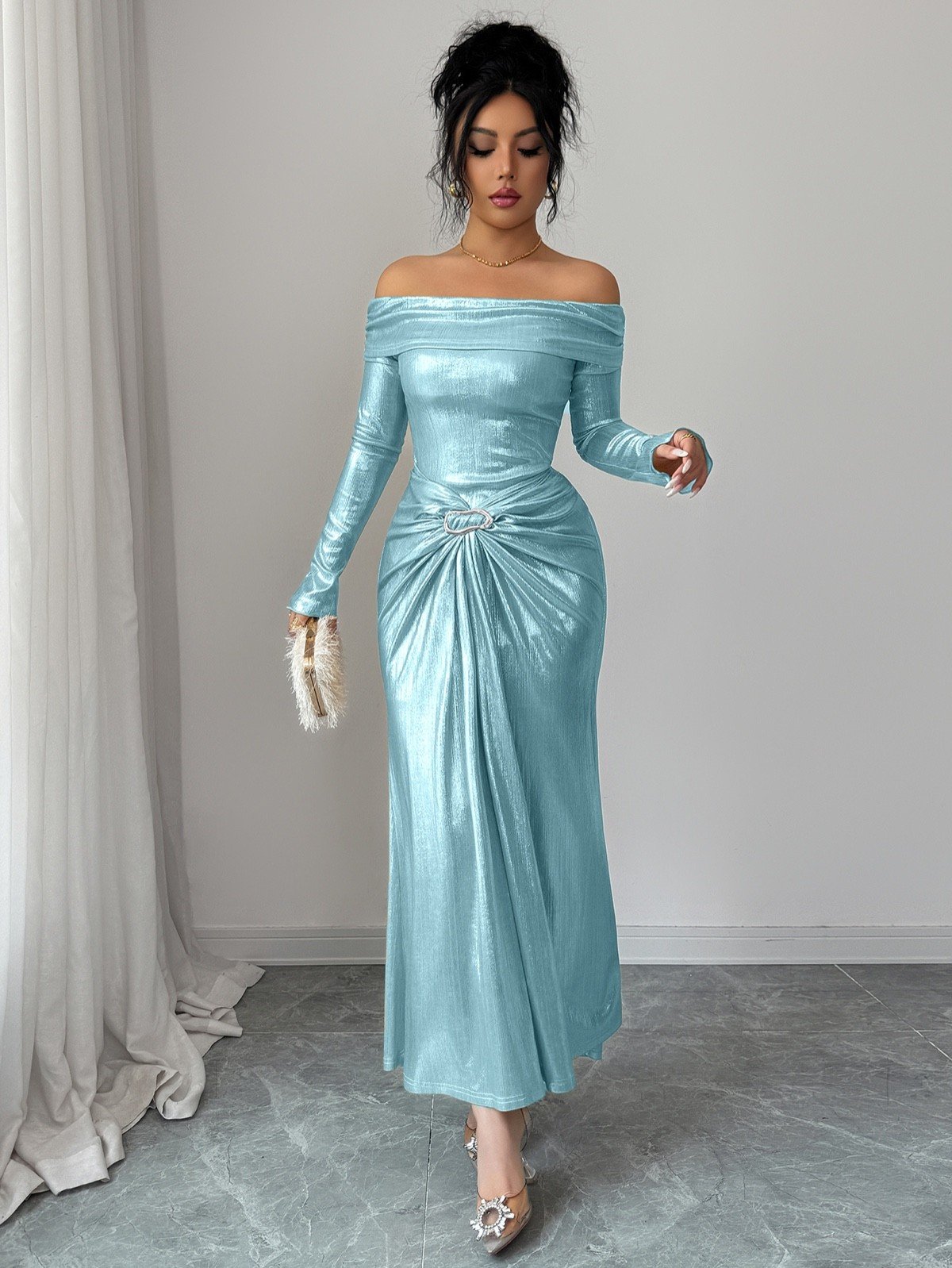 Walking front view of an ice blue metallic off-shoulder maxi dress with a ruched buckle waist.