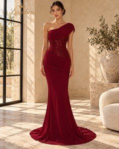 Front view of a burgundy one shoulder sequin evening gown with asymmetric draping, fitted embellished bodice and floor-length skirt.