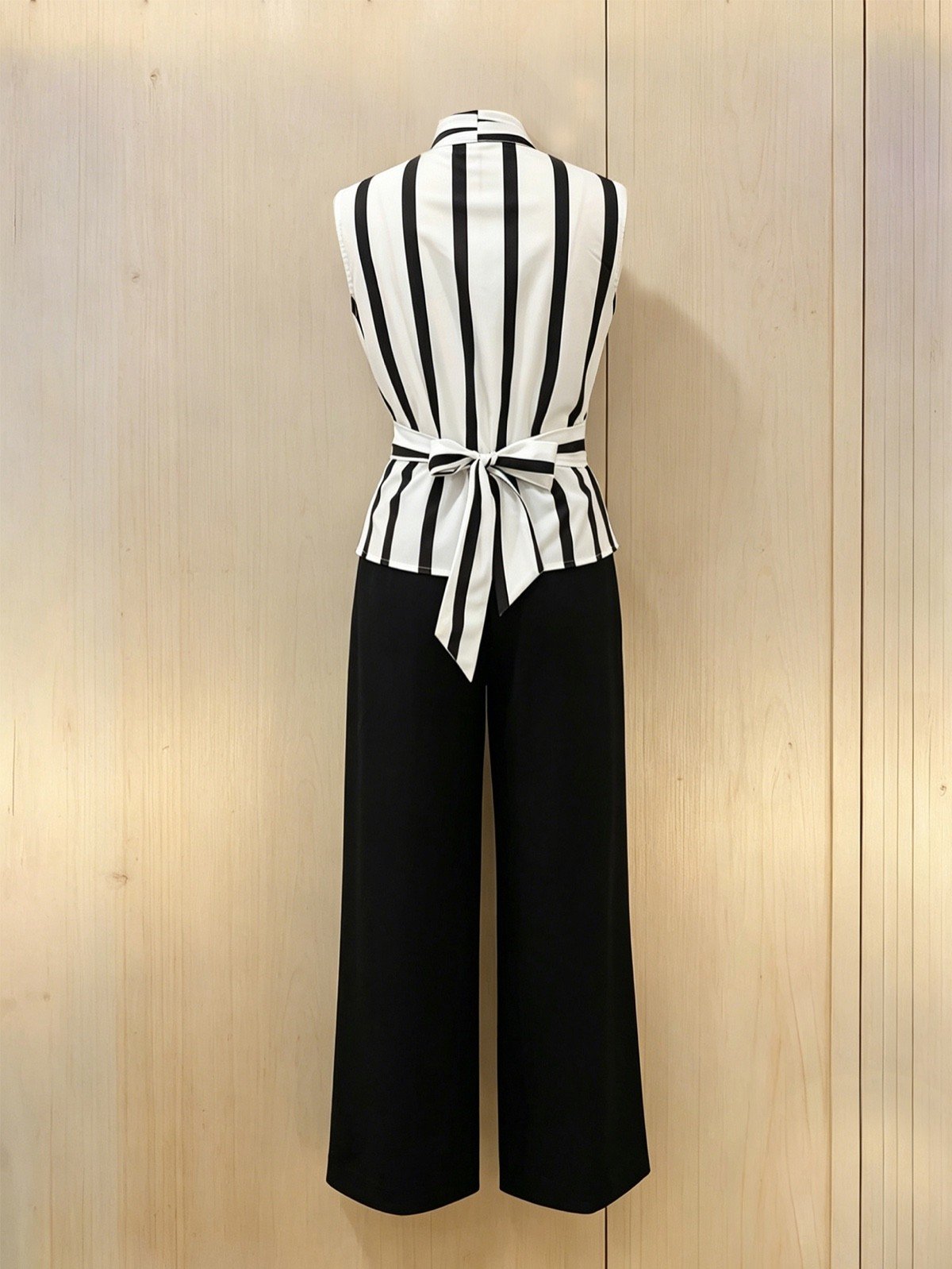 Back hanger display of a striped wrap blouse and black wide-leg pants set with buckle detail.