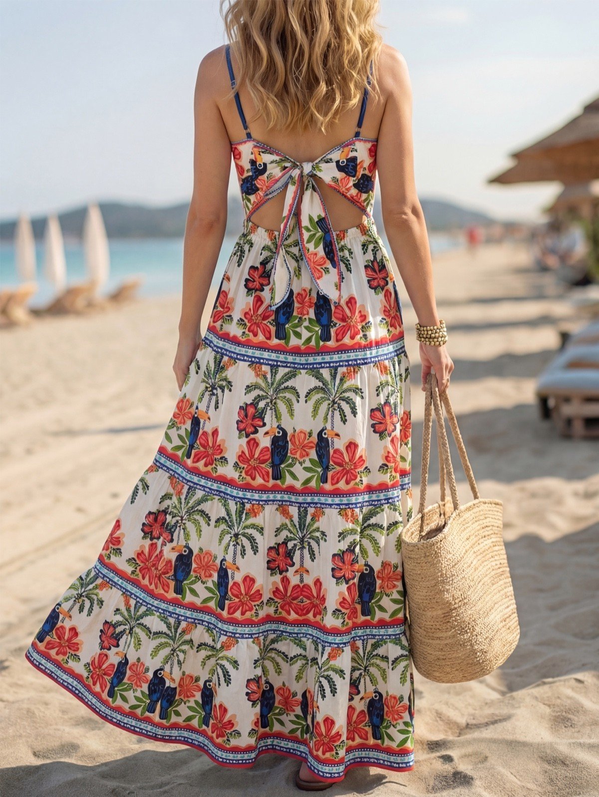 Tie-back view of a tropical print tiered maxi sundress with slim straps and a tie back.