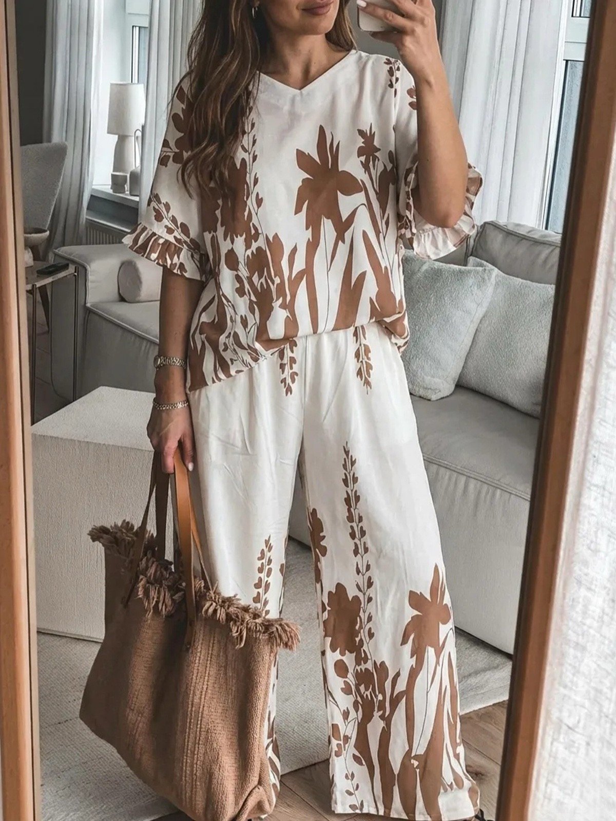 Indoor lifestyle view of a tropical print short-sleeve top and wide-leg pants set.