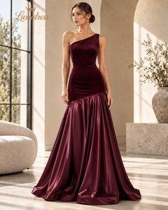 Front view of a burgundy one shoulder evening gown with a fitted velvet-look bodice and full satin-look floor-length skirt.
