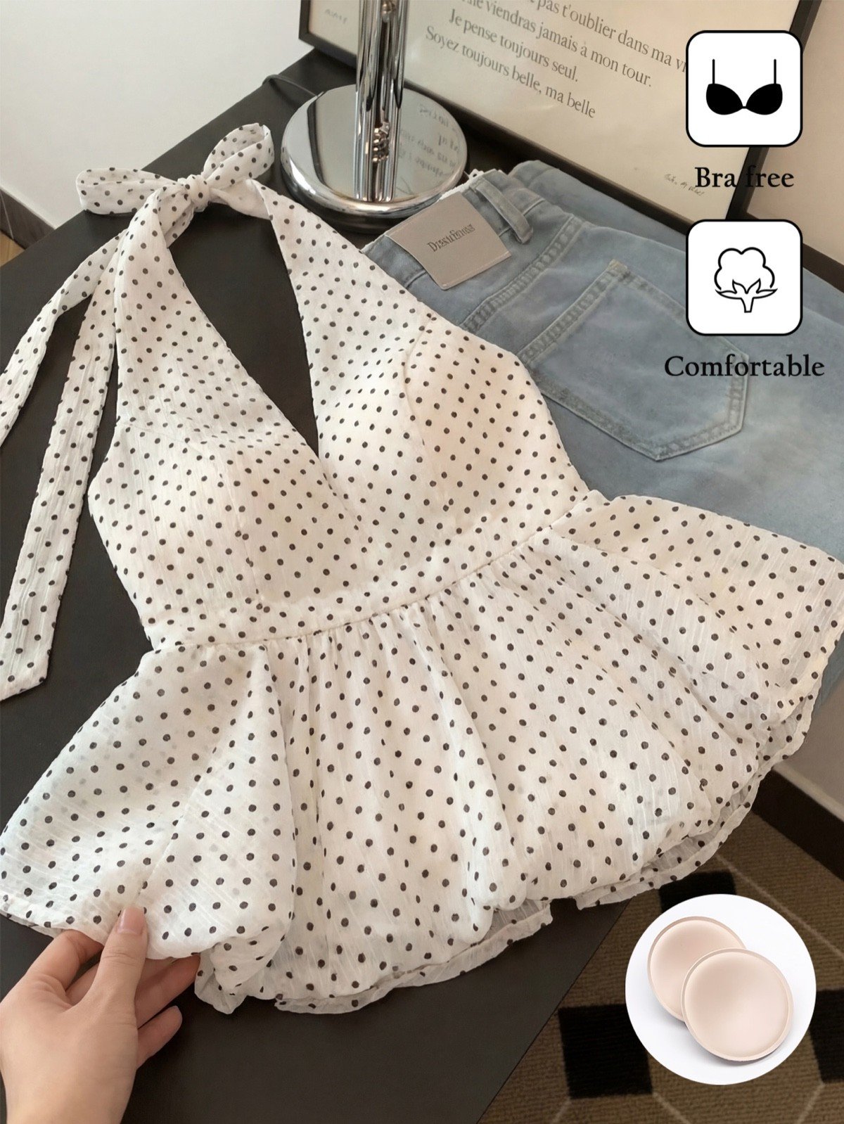 Built-in cup detail of a white polka-dot halter peplum top with a tie back.