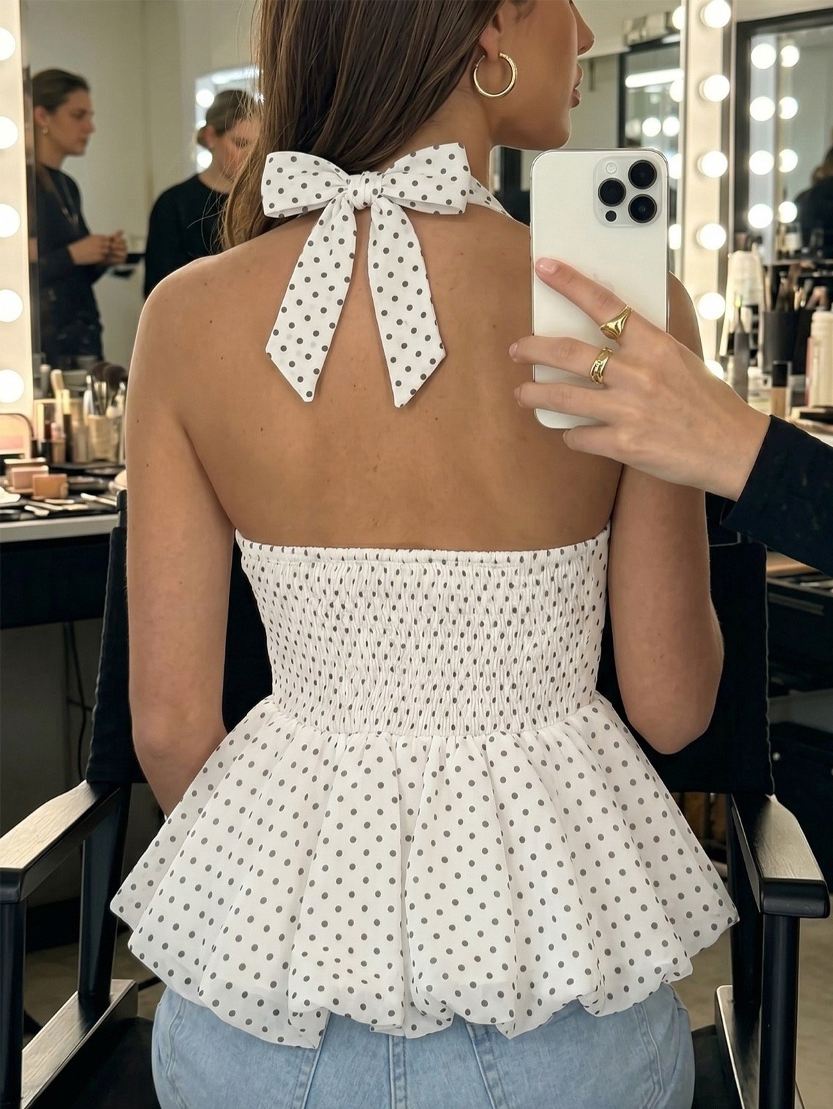 Tie-back view of a white polka-dot halter peplum top with a tie back.