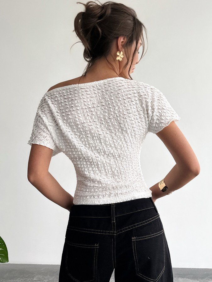 Back view of a white textured off-shoulder fitted top with short sleeves.