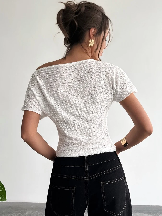 Back view of a white textured off-shoulder fitted top with short sleeves.